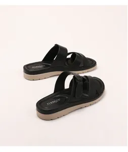 Close-up of matte black leather cross straps and textured beige platform sole detail