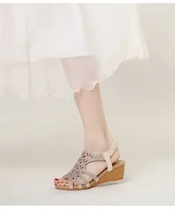 Détail de sandales à talons compensés avec strass, motif ajouré et bride arrière élastique