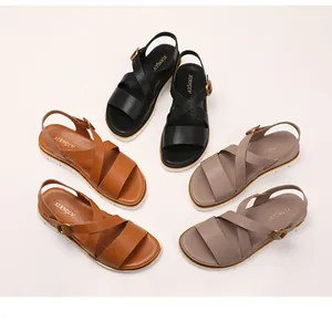 Overhead view of cross-strap wedge sandals in black, brown, and taupe with metal buckles
