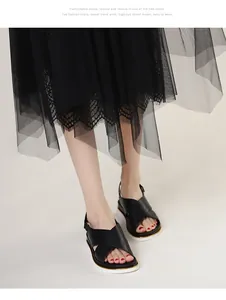 Detail of women's black platform sandals with cross-straps and gold-trimmed soles