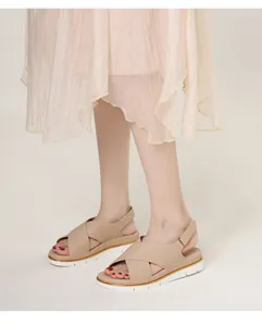 Detail of beige platform sandals with gold trim and non-slip white soles for beach wear