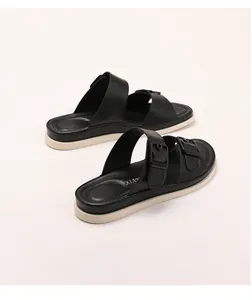 Detailed macro view of black double-strap sandals with buckle and cushioned platform sole