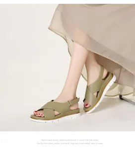 Side view of olive green platform sandals with crossover straps and metallic buckle detail