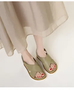 Olive green platform sandals with crisscross straps and gold trim on white sole