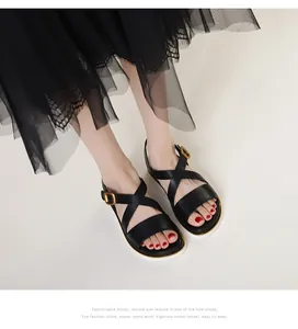 Detailed top view of black leather cross-strap wedge sandals with gold buckle and soft sole