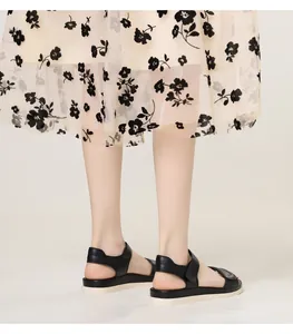Detail view of black platform sandals featuring velcro straps and soft white wedge soles