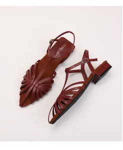 Detail of burgundy multi-strap woven sandals with T-bar and adjustable buckle closure