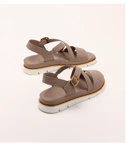 Detail of khaki wedge roman sandals featuring golden trim and white serrated non-slip sole