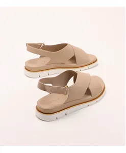 Detailed view of beige platform sandals with cross straps and adjustable ankle buckle strap