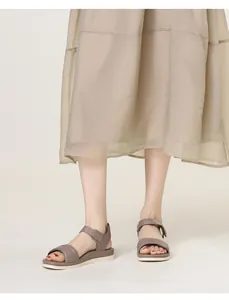 Detail of taupe walking sandals featuring quilted straps and adjustable velcro closure