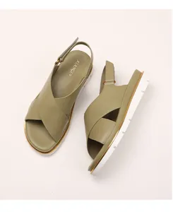 Detail view of khaki green platform sandals with crossover straps and gold trim accents