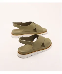 Detail of olive green platform sandals with crossover straps and gold trim on sole