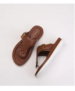 Detail of brown thong sandals with metal buckle and thick white non-slip sole