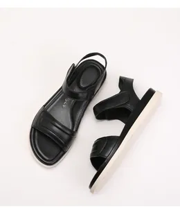 Detailed top and side view of soft black sandals with breathable perforated footbed