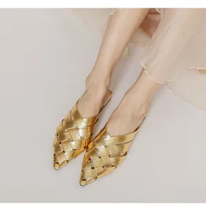 Detailed close-up of gold woven texture and pointed toe design on fashion mule shoes