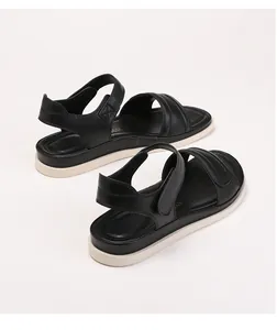 Detail view of adjustable velcro straps and smooth black leather on thick white soles