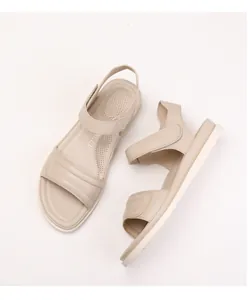 Detail view of beige velcro sandals with breathable perforated footbed and soft sole