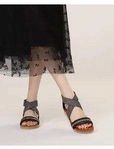 Detail of woven strap with sparkling rhinestones and grey elastic band on wedge sandals
