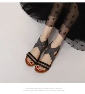 Detail view of woven bohemian sandals featuring glitter straps and rhinestone chain decoration