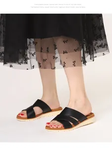 On-foot shot of black cross-strap slide sandals with thick beige sawtooth soles