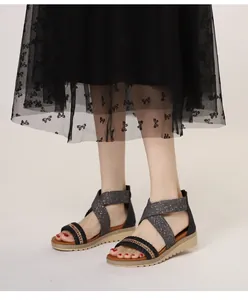 Detail of woven rhinestones on cross-strap wedge sandals with glittery platform sole