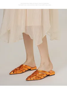 Macro detail of copper braided pointed-toe mule sandals styled with a pleated skirt