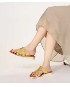 Detail of gold metallic crisscross straps and platform sole on casual women sandals