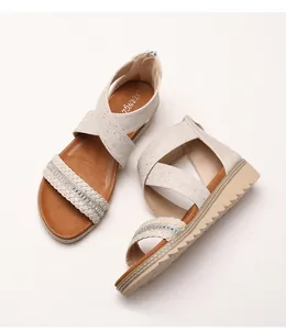Close-up of rhinestone woven strap and platform sole on beige gladiator wedge sandals