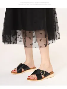 Detail showing the black cross straps and gold square buckle on these platform sandals