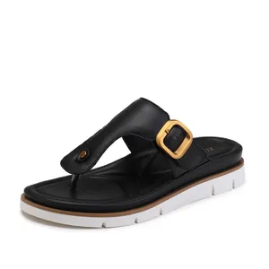 Fashionable black thong sandals for women with large gold buckle and platform sole