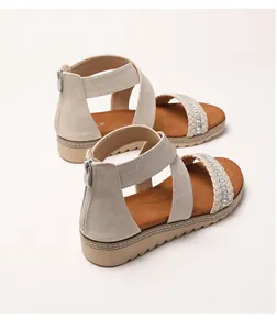 Detailed view of rhinestone-embellished woven straps and wedge sole on women's sandals