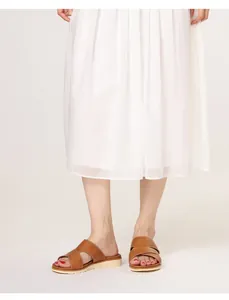 Detail view of brown leather slide sandals with white stitching on thick platform sole