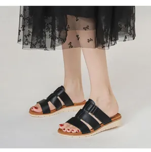 Détail de sandales compensées noires à brides avec semelles antidérapantes contrastées