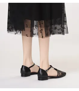 Close-up of black woven leather fisherman sandals with adjustable ankle strap detail