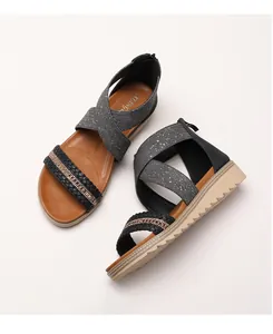 Detail of bohemian wedge sandals featuring sequined woven straps and crisscross elastic bands