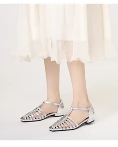 Detail of silver metallic woven gladiator sandals with T-strap buckle and closed toe
