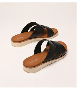 Detail view of black crisscross leather straps and thick platform sole on summer sandals