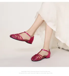 Detail view of woven metallic rose red flat sandals with adjustable T-strap buckle