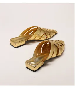 Close-up of golden woven pointed-toe mule with metallic texture and low block heel