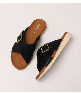Top view of platform sandals with black cross straps and decorative gold square buckles
