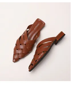 Detail of woven brown leather texture and pointed toe on these stylish summer mule sandals
