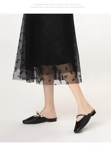 Close-up of elegant black pointed-toe mules with sparkling silver rhinestone strap