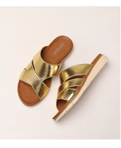 Detailed top view of gold metallic cross strap sandals with thick cushioned white sole