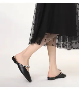 Detailed view of women's black pointed-toe mules featuring elegant rhinestone straps