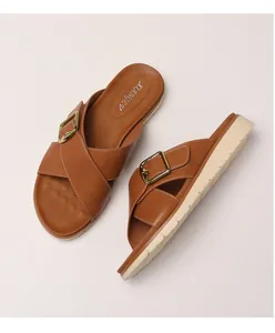 Detail view of brown cross-strap platform sandals with golden square buckles and anti-slip sole