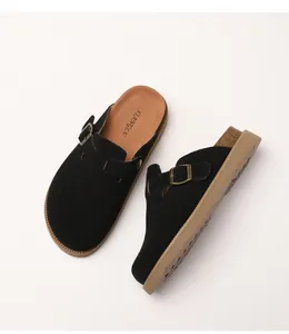 Detailansicht der schwarzen Wildleder-Clogs mit verstellbarer Metallschnalle und Korksohle