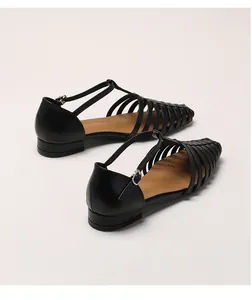 Detail view of woven black leather fisherman sandals with adjustable metal T-strap buckle