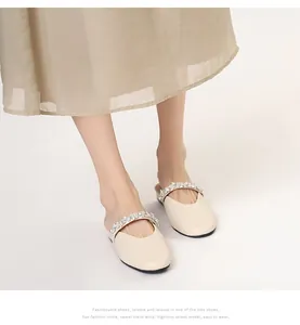 Close-up of elegant cream mule shoes with sparkling rhinestone straps on model
