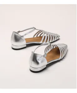 Detail showing the silver cage-style woven toe and metal buckle on the flat sandal