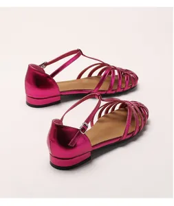 Close-up of fuchsia woven leather sandals with T-strap and buckle details